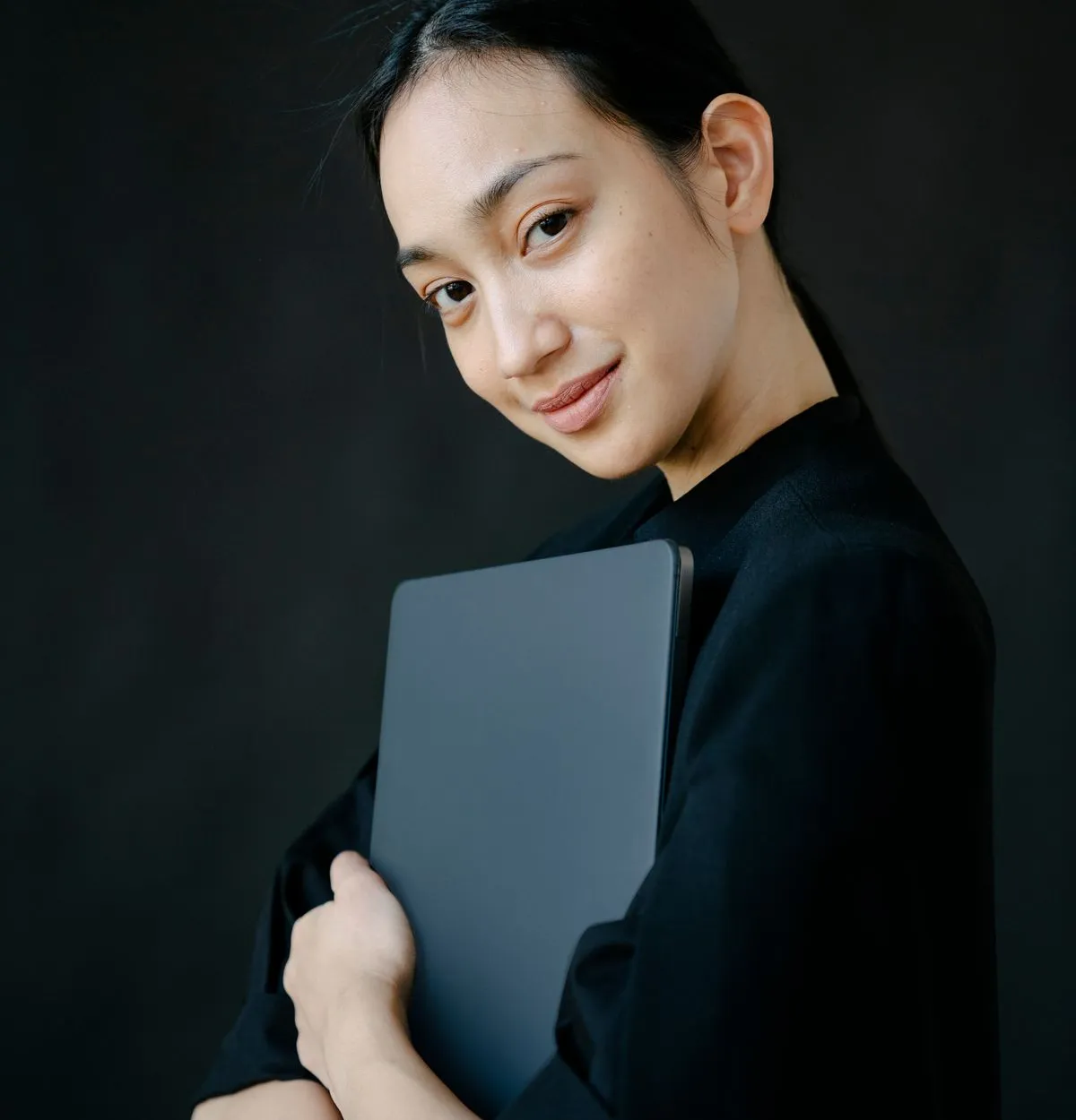 Nữ doanh nhân ôm laptop trên nền đen